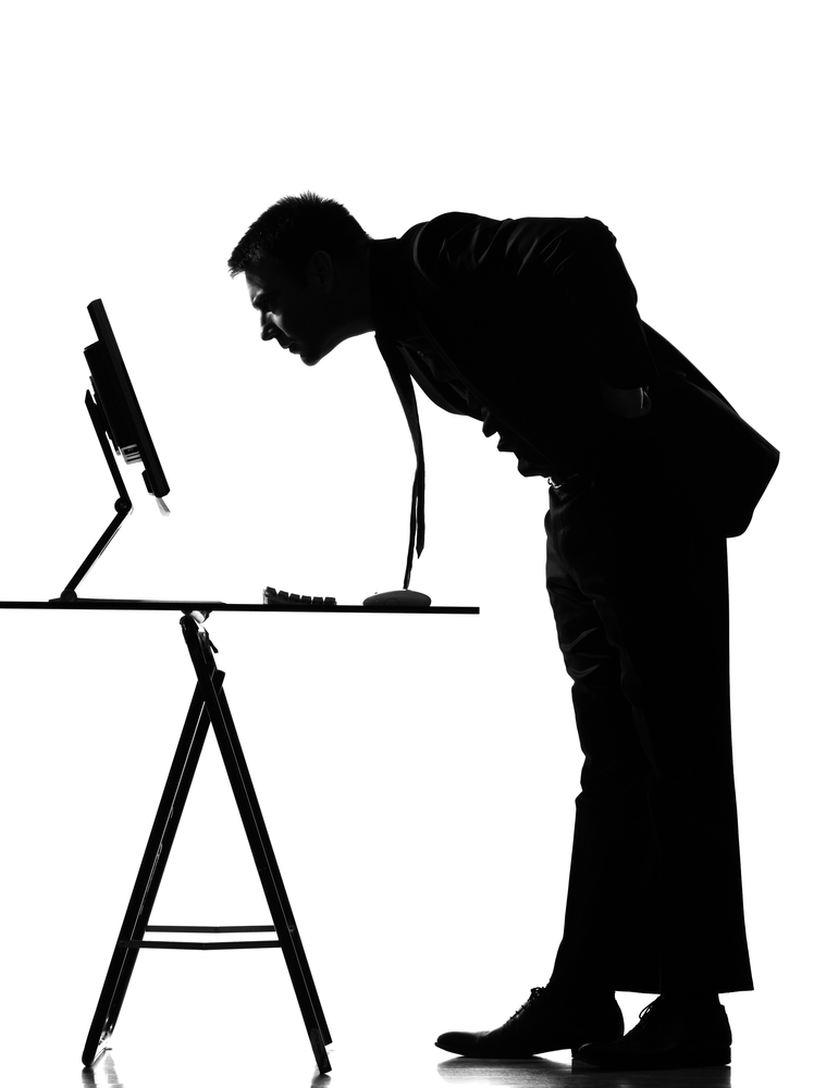 person hunched over computer on desk